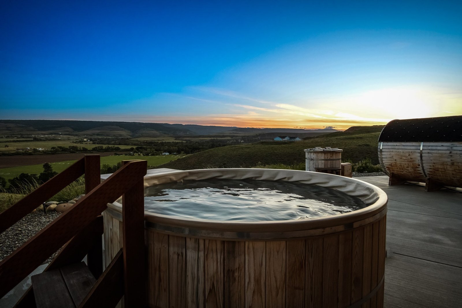 Hot tub and barrel sauna overlooking the valley at sunset