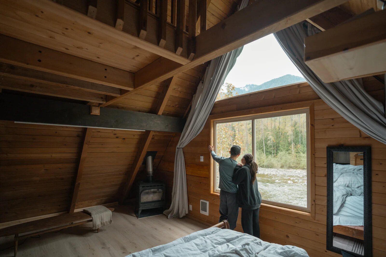 Interior A-frame view of forest through large windows in spring